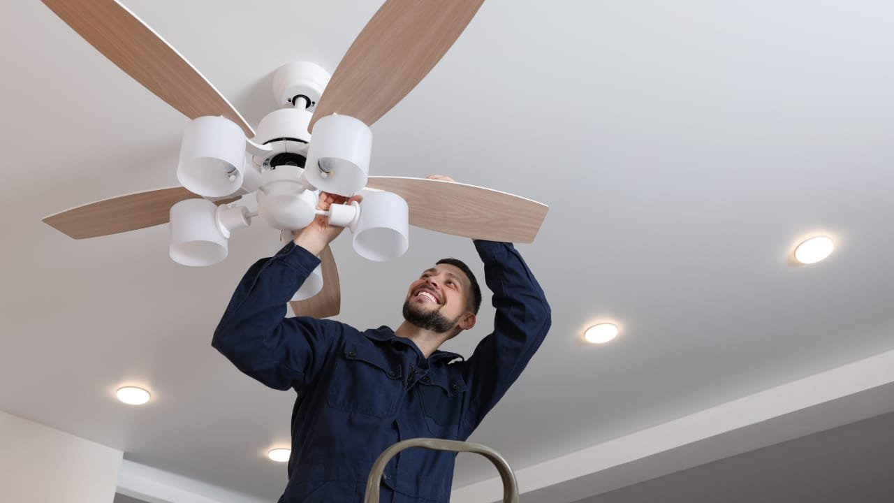 a man fixing celling fan